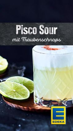 a close up of a drink in a glass with limes on the side and an ad for pisco sour