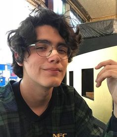 a young man wearing glasses sitting at a table