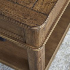 a close up of a drawer on a wooden table with carpeted area in the background