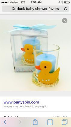 two yellow rubber ducks sitting in a clear glass container with blue ribbon on the top