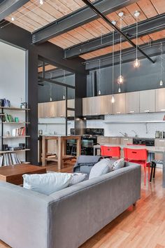 a living room filled with furniture next to a kitchen and dining room table on top of a hard wood floor