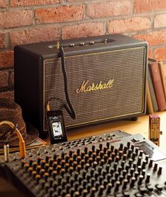 an old fashioned radio sitting on top of a wooden table next to a brick wall