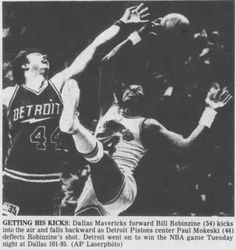 an old newspaper clipping with a basketball player trying to block the ball from being blocked by another player