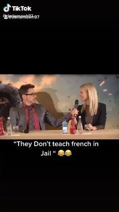 two people sitting at a table talking to each other in front of a screen with the caption they don't teach french in jail