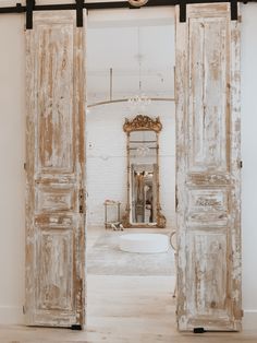 an open door leading to a white bathroom