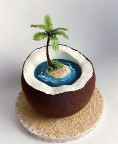 there is a small palm tree in the middle of a desert cake with blue water inside