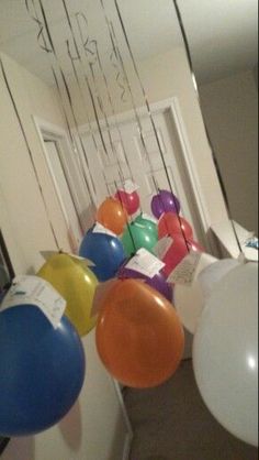 several balloons are hanging from the ceiling in an office hallway, with writing on the walls