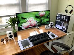 a computer desk with a keyboard, mouse and monitor on it in front of a window