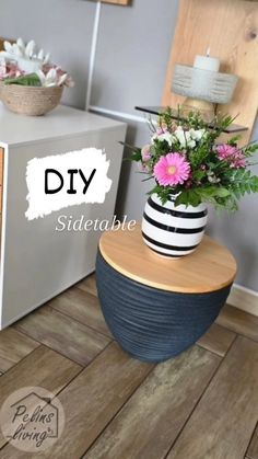 a vase with flowers sitting on top of a wooden table next to a white refrigerator