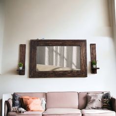 a living room with a couch and mirror on the wall