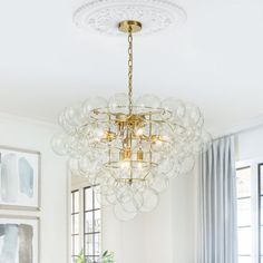 a dining room table with chairs and a chandelier hanging from it's ceiling