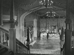 an old black and white photo of a hall with chandeliers
