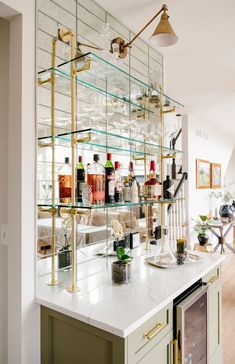 a bar with lots of bottles and glasses on top of it, next to a wall mounted wine rack