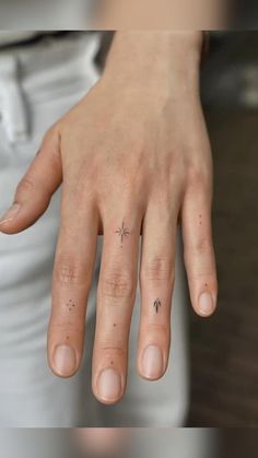 a woman's hand with a tiny star tattoo on it