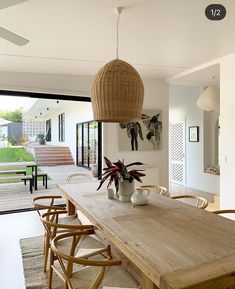 a dining room table with chairs and a potted plant on top of it in front of a sliding glass door