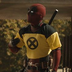 a man dressed as deadpool holding a baseball bat