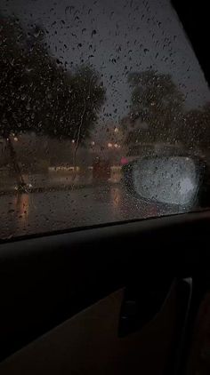 rain is pouring down on the windshield of a car