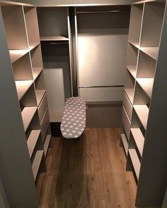 an empty walk in closet with ironing board