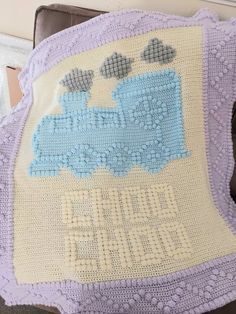 a crocheted blanket with a train on it