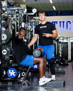 two men in the gym posing for a photo