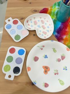 the table is covered with colorful plates and paintbrushes, including one that has been painted