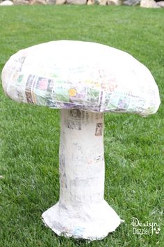 a paper mache mushroom sitting in the grass