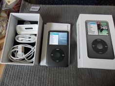 an apple ipod sitting in a box on top of a table next to other items
