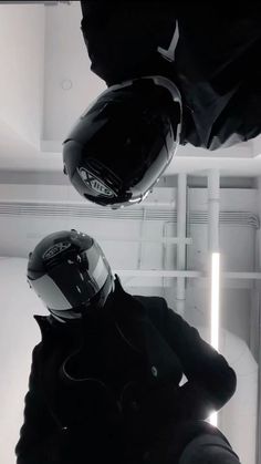 two people wearing helmets in a white room