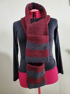 a red and gray scarf on top of a mannequin