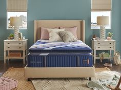 a bedroom with blue walls and furniture in the corner, including a mattress on an end table