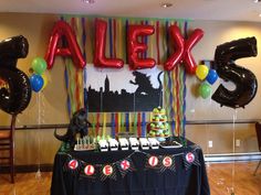 a table with balloons and cake on it in front of a sign that says alex 5