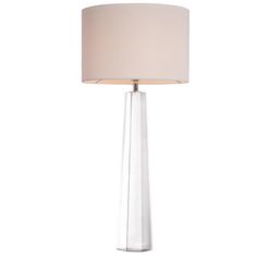 a lamp that is on top of a table with a white shade over the base