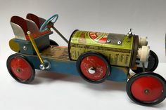 a toy car made out of tin cans with wheels and spokes on the front