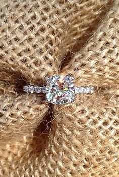 a diamond ring sitting on top of a piece of fabric