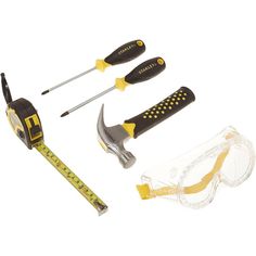 tools and safety glasses are laid out on a white surface, including a measuring tape