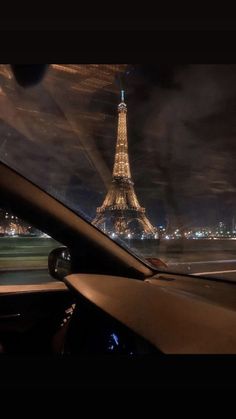 the eiffel tower is seen from inside a car at night in paris, france