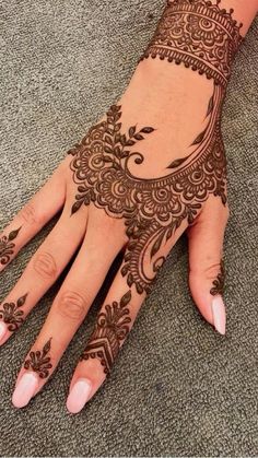 a woman's hand with henna tattoos on it