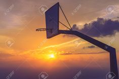 a basketball hoop with the sun setting in the background stock photo - 957982