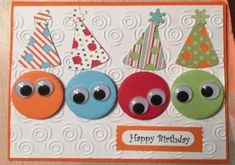 a birthday card with three different colored buttons and one has an eyeball on it