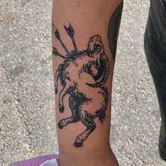 a person with a tattoo on their arm holding onto an object in the shape of a bear