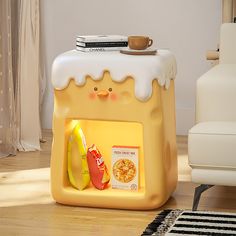 a yellow toy oven with food in it on the floor next to a white chair