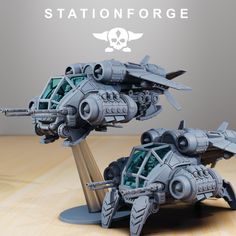 two model ships sitting on top of a wooden table next to each other with the words stationforge written above them