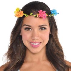 a woman with flowers in her hair wearing a blue tank top and smiling at the camera