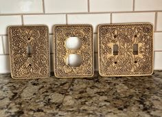 three decorative switch plates sitting on top of a counter