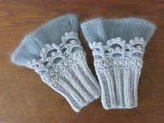 two knitted mittens sitting on top of a wooden table