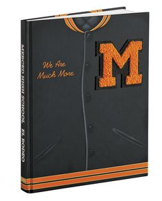 an orange and black book with the letter m embroidered on it's front cover