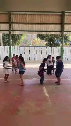 several children are playing in an indoor basketball court