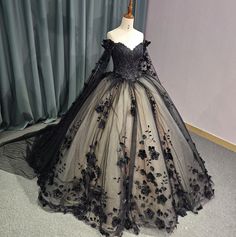 Timeless vintage-inspired Black Sweetheart Quinceanera Dress. Featuring an intricate beadwork bodice, off-the-shoulder long sleeves with a dramatic floral drape shoulder cape, this dress exudes glamour and luxury. The black lace overlay complete with hand sewn florals adds a touch of elegance, while the adjustable lace-up back ensures a perfect fit. Elevate your party look with this exquisite ball gown. material: glitter tulle, organza type: ball gown style: formals color as shown built in bra s Couture, Victorian Ball Gowns Black, Dark Blue And Black Quinceanera Dresses, Black Poofy Wedding Dress, Black And White Ball Gowns, Quinceanera Dresses Black And Pink, Black And Pink Ball Gown, Dark Ball Gown, Ball Gown Dresses Black