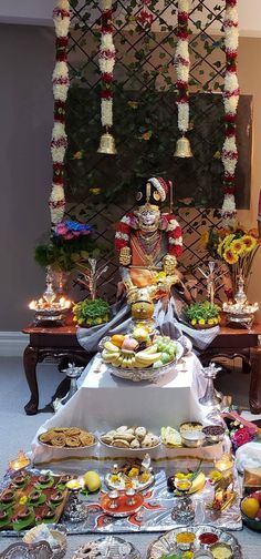 a table filled with lots of food on top of a carpeted floor next to a wall