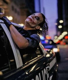 a man with blood on his face sitting in the back of a police car